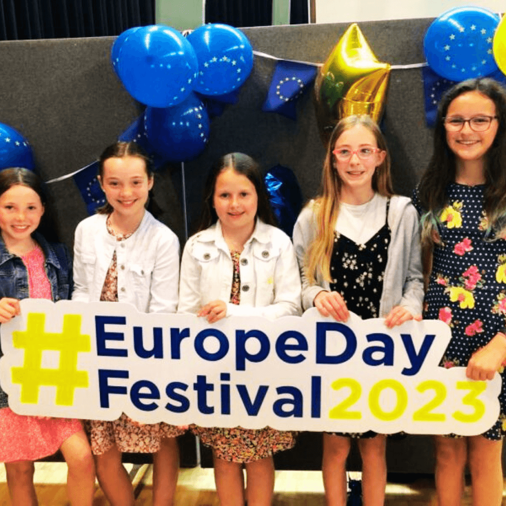 Kids holding the Europe Day Festival 2023 banner